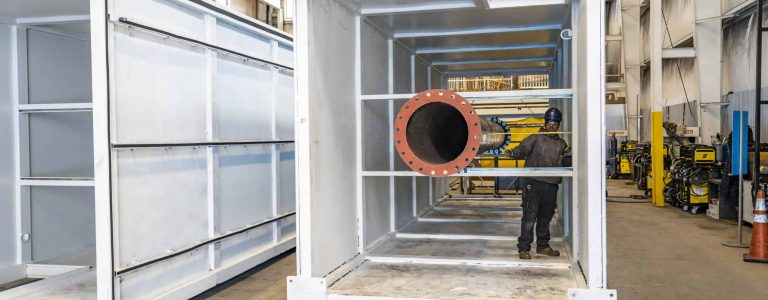 worker measuring plenum exhaust Acoustical Sheetmetal Company