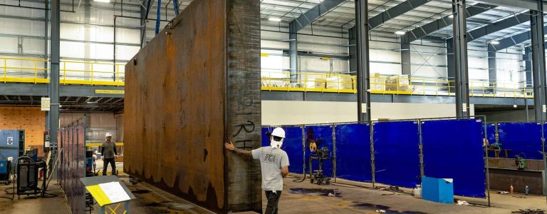 fuel tank being moved by crane in manufacturing facility Acoustical Sheetmetal Company