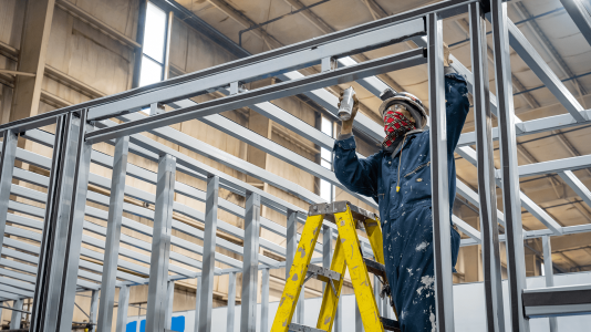 worker painting metal frame of enclosure Acoustical Sheetmetal Company