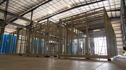 Two large enclosure frames on the production floor of ASC's manufacturing warehouse.