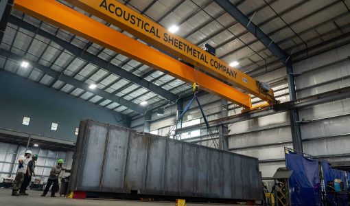 A crane lifting a fuel tank on ASC's production floor.